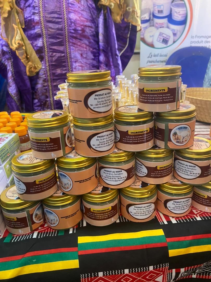 Des pots de produits de membres étiquetés « Produit au Niger » empilés lors d'une foire